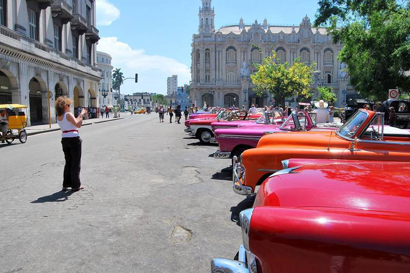 American tourist photographing an old car