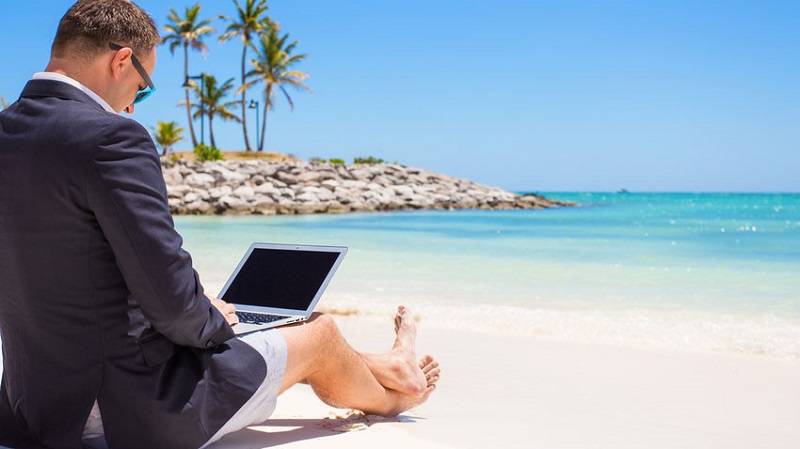 businessman with laptop at the beach