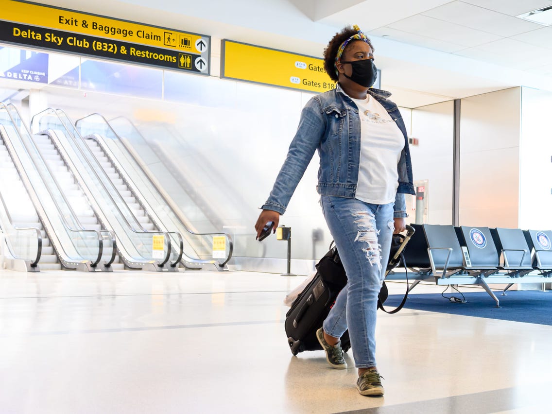 a woman with her carryon bag at an airport