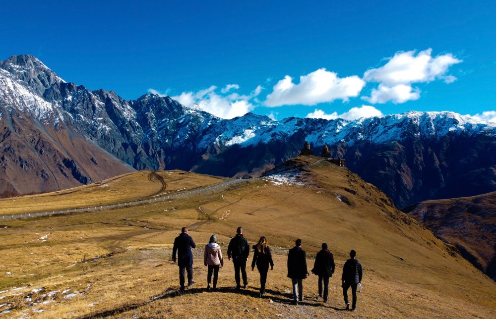 7 people walking in a landscape