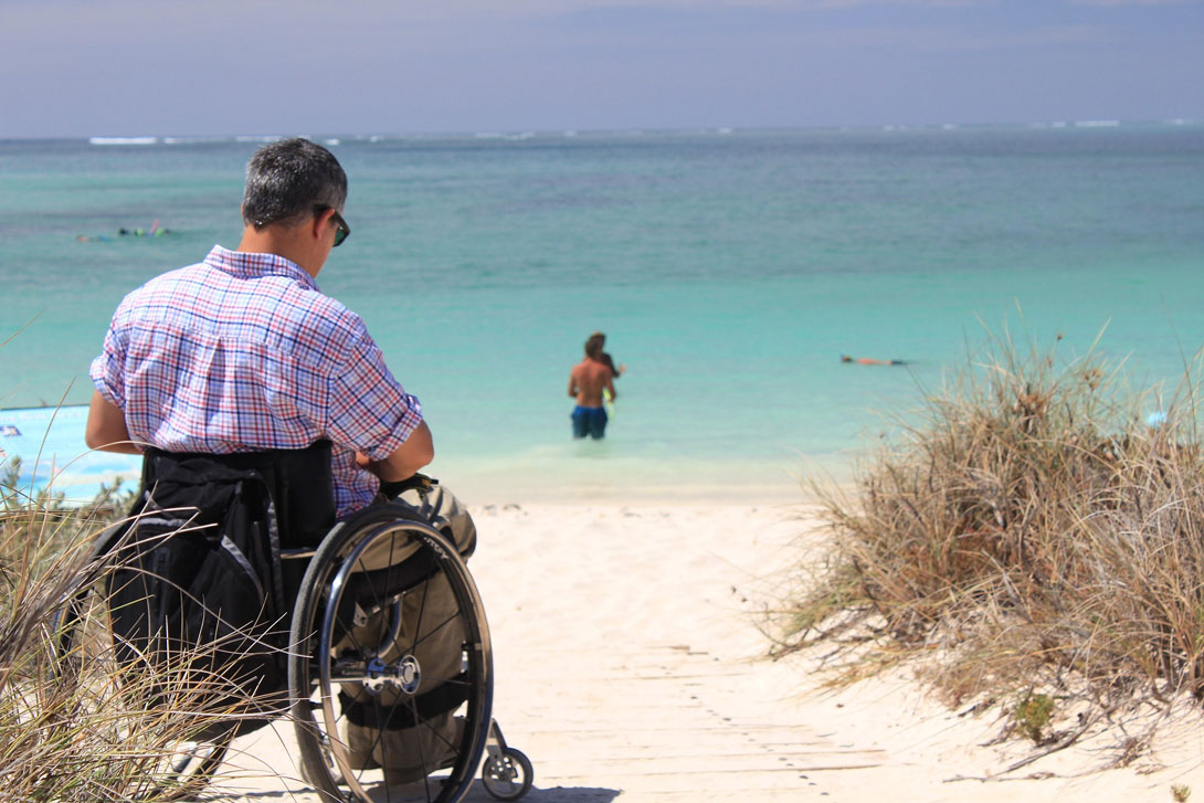 man on a wheelchair at the beach