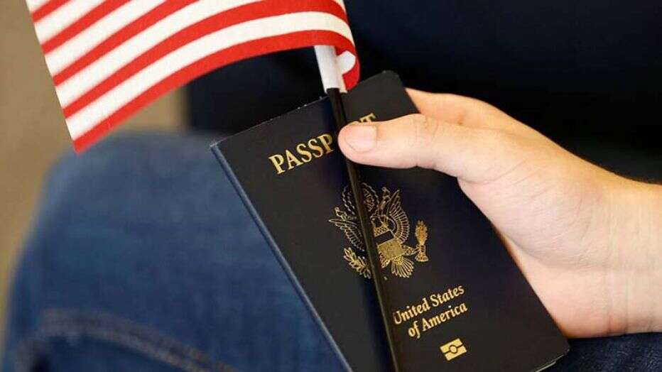 hand holds US passport and flag