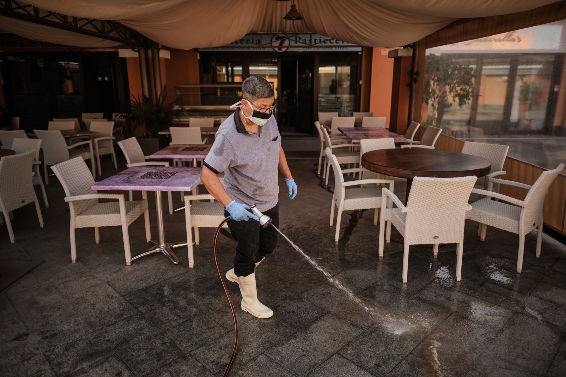 man mopping the floor of hotel restaurant