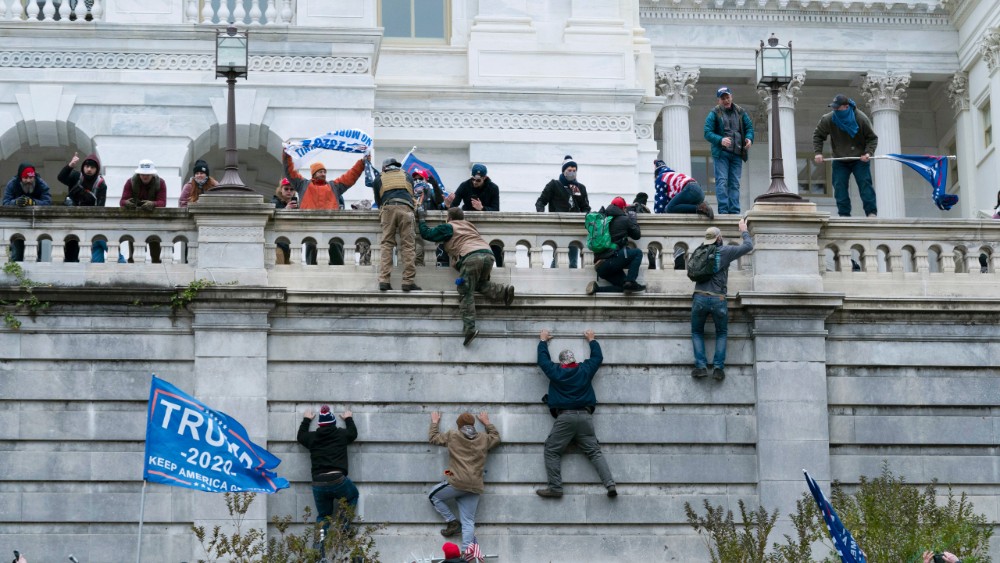 rioters climbing Capitol walls