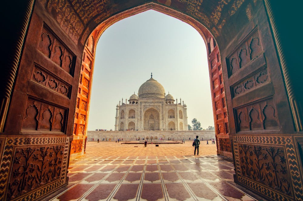 Taj Mahal in the distance, viewed through opened gates