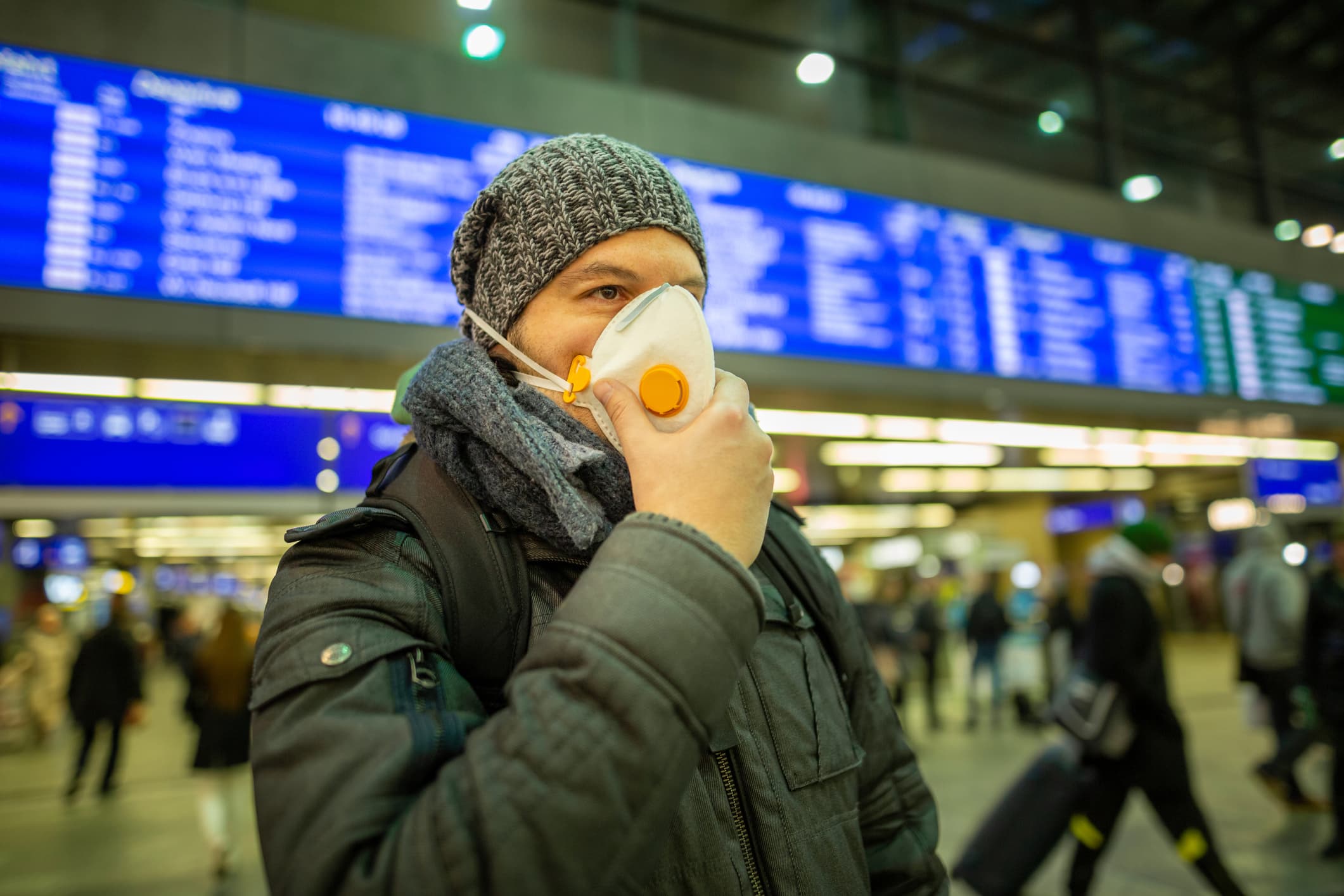 traveler putting mask on at airport