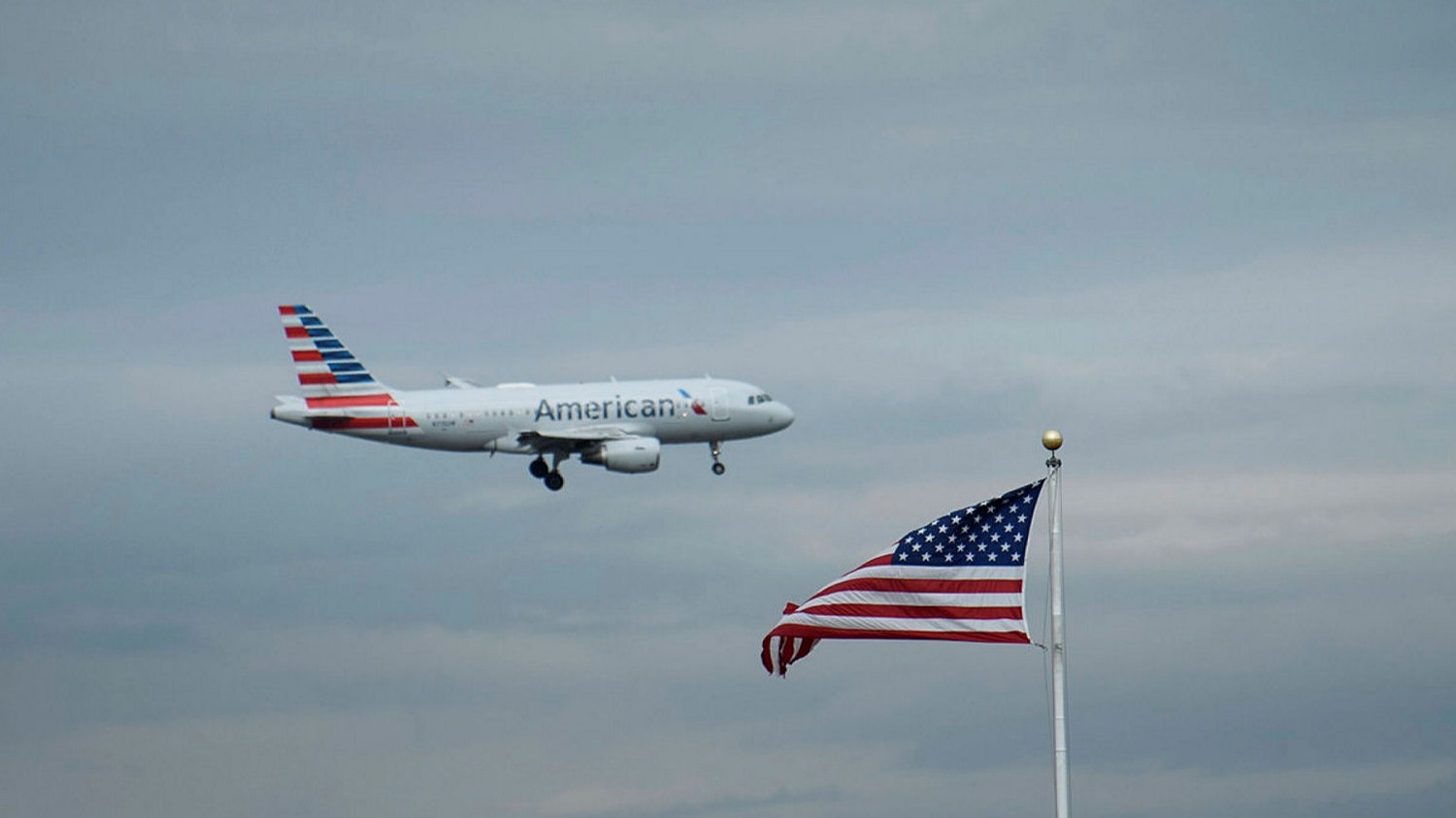 AA airliner in the air and American flag